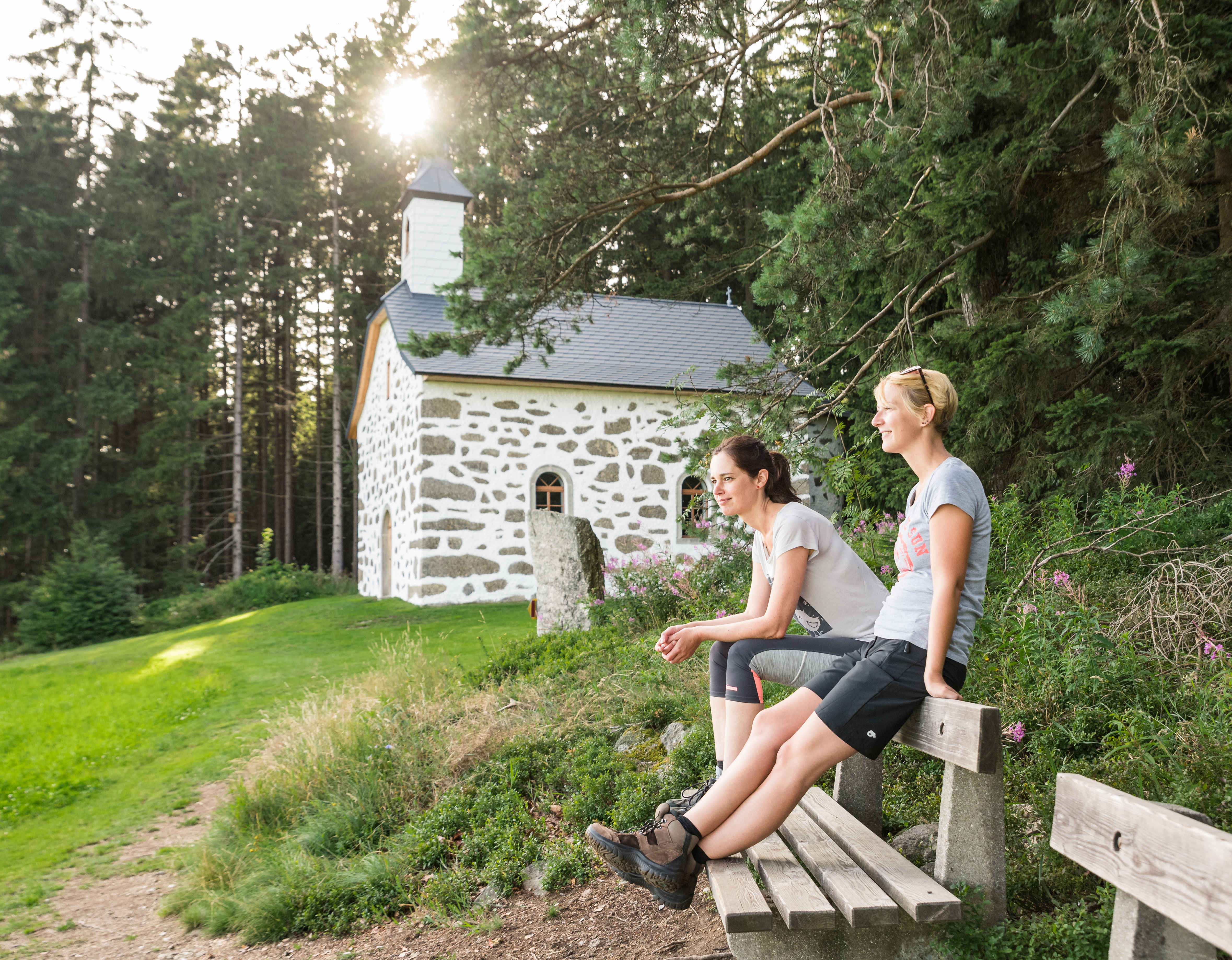 2 Frauen sitzen auf einer Bank beim Kammerberg, Station 7 am Johannesweg